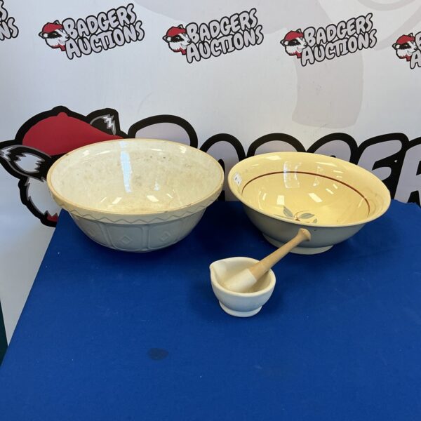 Vintage ceramic mixing bowls and mortar and pestle set for kitchen use.