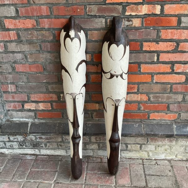 Pair of vintage African carved wood masks with expressive features.