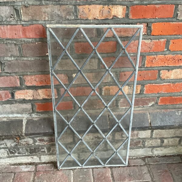 Antique leaded glass window panel with a diamond pattern.