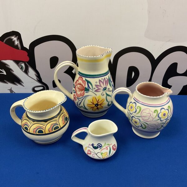 Vintage Poole and Honiton pottery jugs in a floral collection.