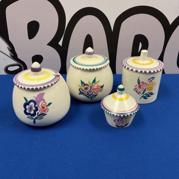 Vintage Poole Pottery preserve pots with floral design.