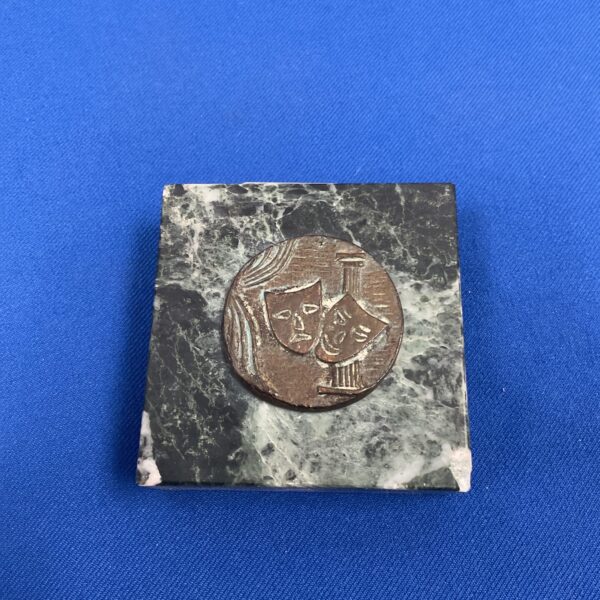 Vintage theatre medallion with bronze masks on green marble base.