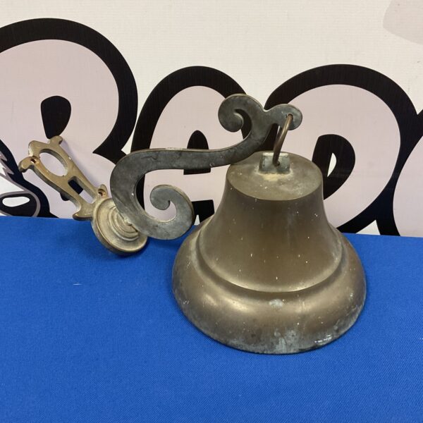 Vintage brass bell with wall bracket, antique home decor.