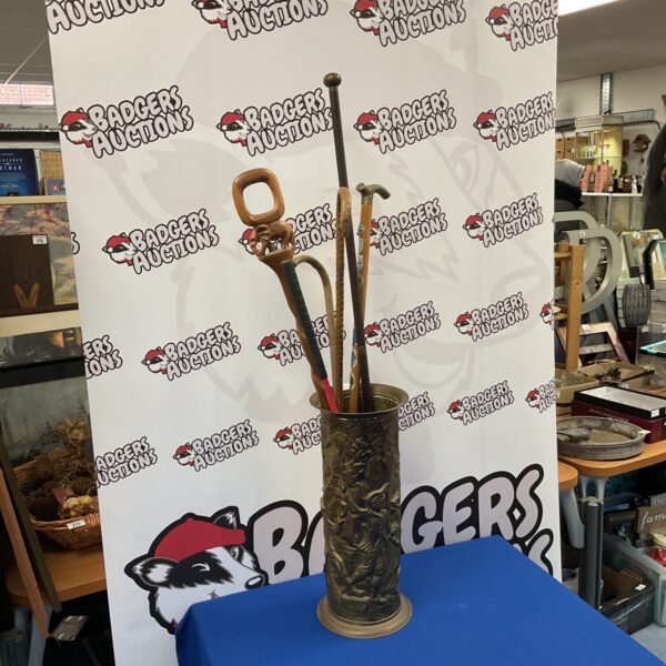 Vintage brass stick stand with selection of walking sticks.