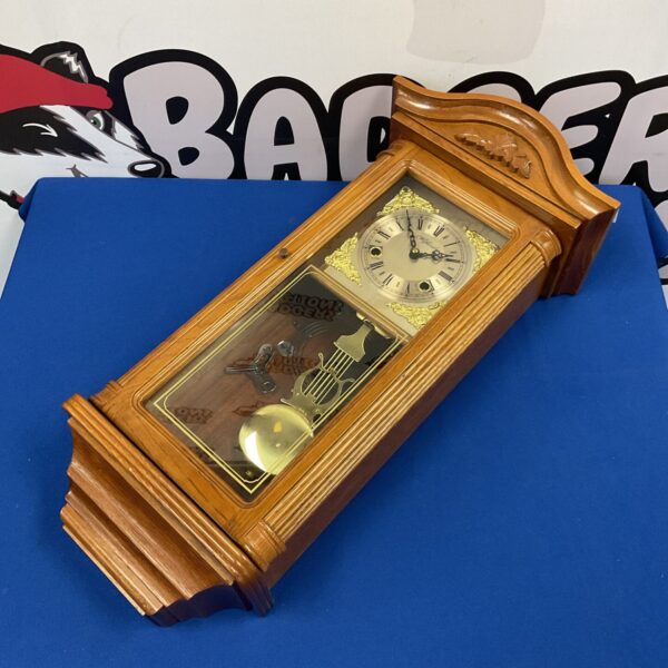 Antique Highland wall clock with oak case and Roman numerals.