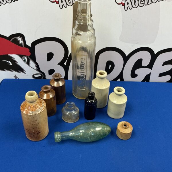 Vintage Essolube oil bottle with stone and glass jars, collectible automobilia.