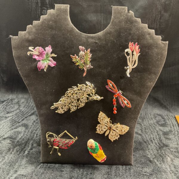Assorted vintage brooches displayed on a stand, a jewellery collection.