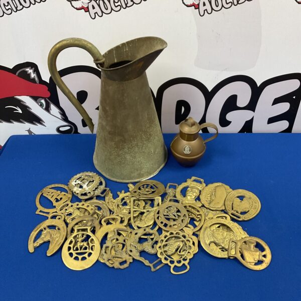 Antique horse brasses collection with a vintage jug.