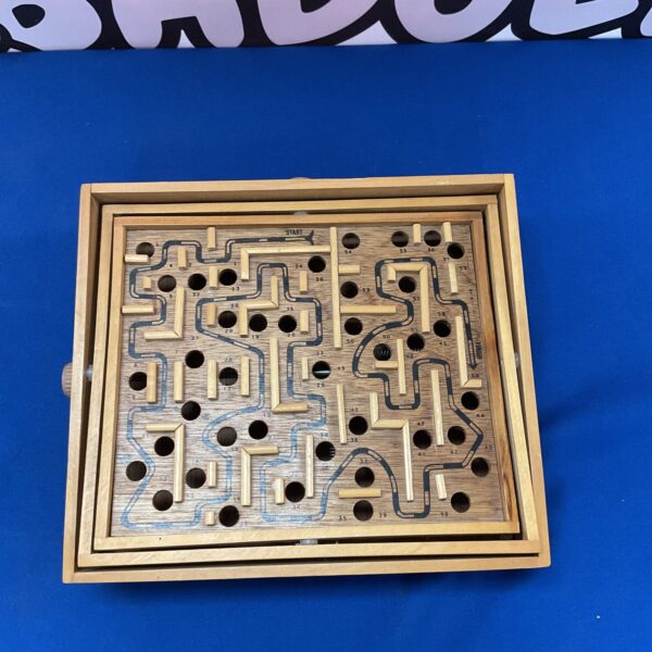 Vintage wooden marble puzzle with intricate maze design.