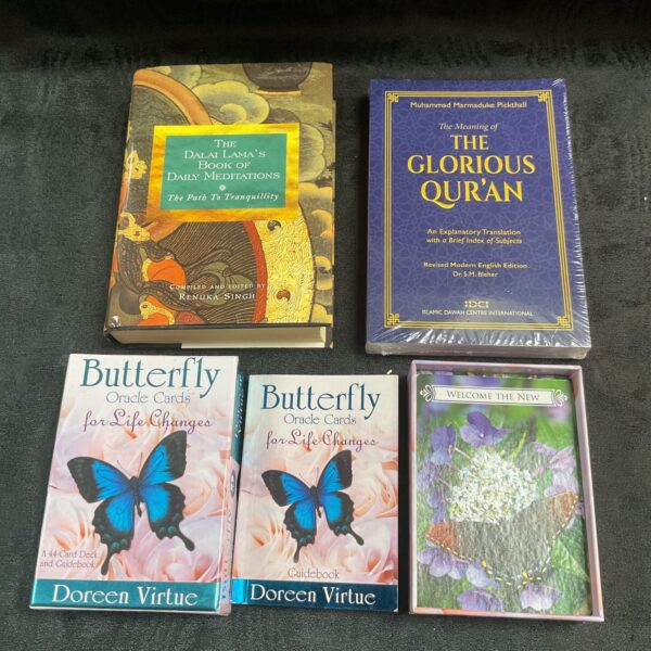 Spiritual lot including Dalai Lama book, Quran, and Butterfly Oracle Cards.