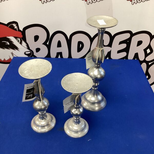 Set of three silver effect candle sticks for home decor.