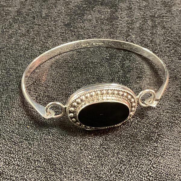 Vintage silver locket bangle with black stone detail.