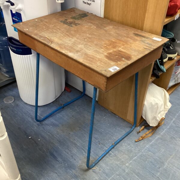 Vintage wooden school desk with metal frame, showing signs of wear.