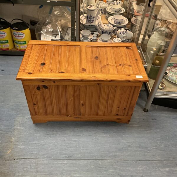 Front view of a rustic pine storage box with a lift-top lid.