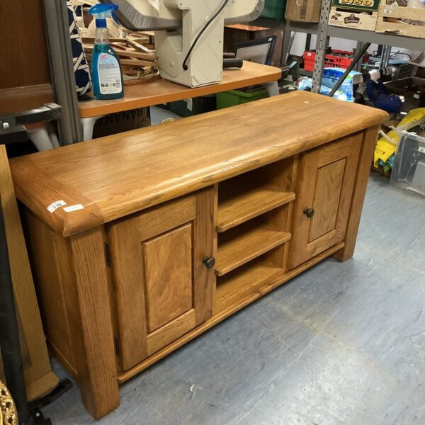 Vintage oak TV stand with cabinet storage for media equipment.
