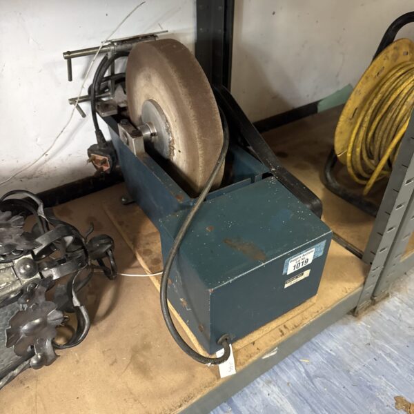Vintage bench grinder with wetstone wheel for metalworking.
