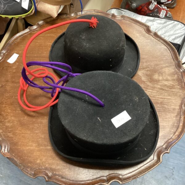 Vintage top hat and bowler hat ceiling lights displayed on a table.