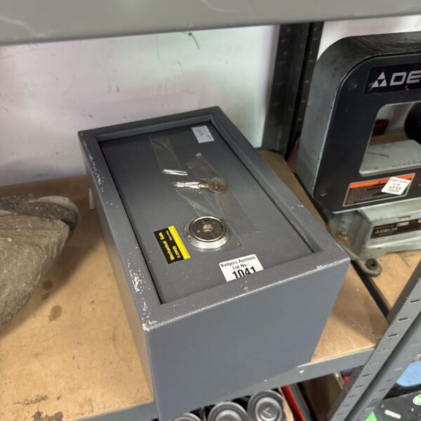 Metal personal safe with key lock for securing valuables.