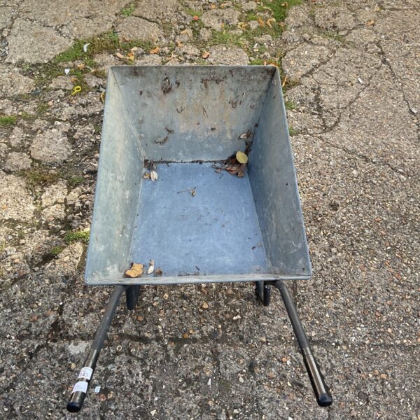 Vintage metal garden wheelbarrow with signs of wear.