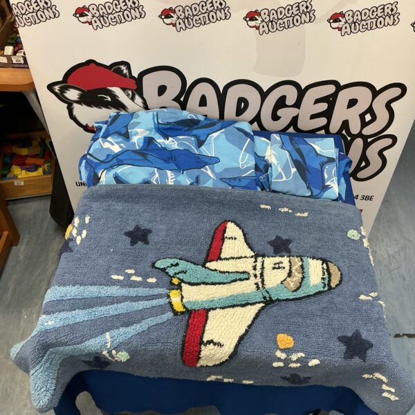 Colourful shark quilt cover set with spaceship rug displayed.