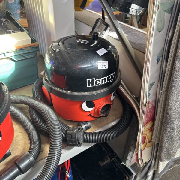 Red Numatic Henry Hoover with pole attachment for cleaning.