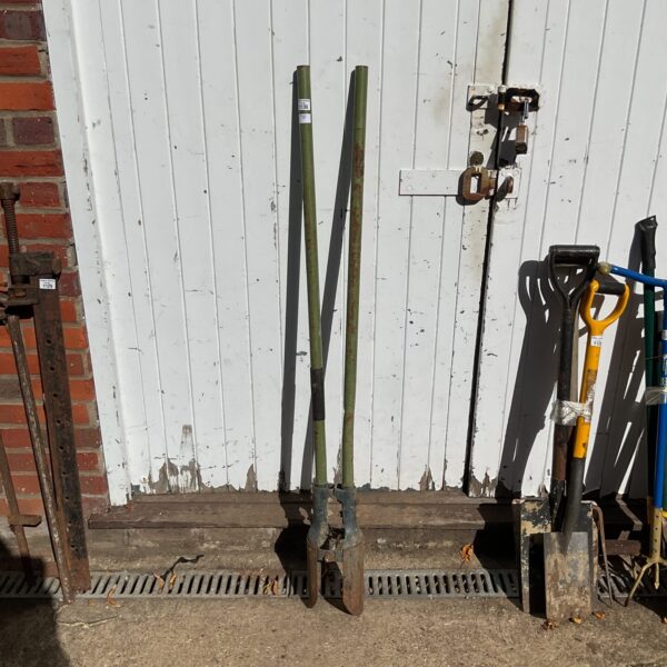 Vintage post hole digger with metal handles and digging blades.