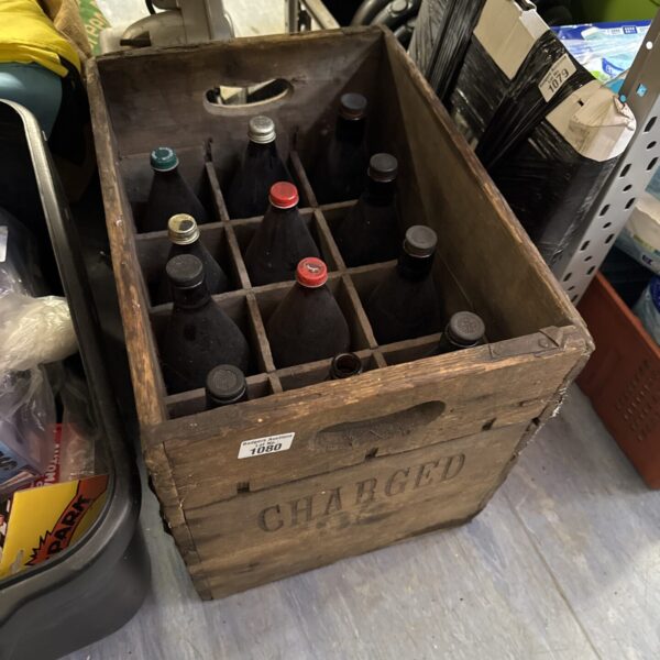 Vintage Harrods wooden bottle crate with empty bottles on display.