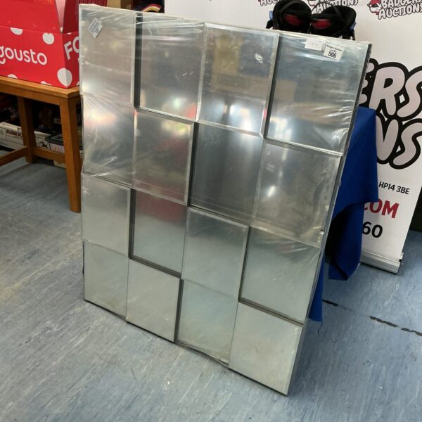 Vintage faceted wall mirror with geometric design.