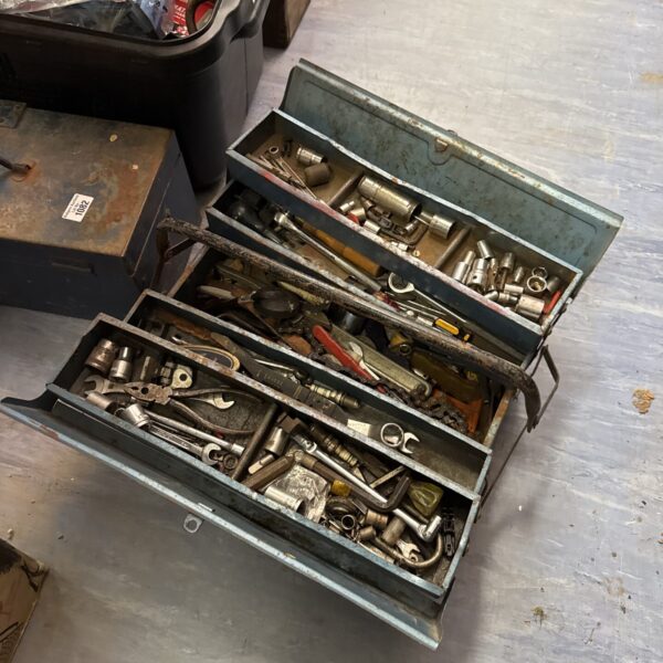 Open vintage cantilever toolbox displaying various tools inside.