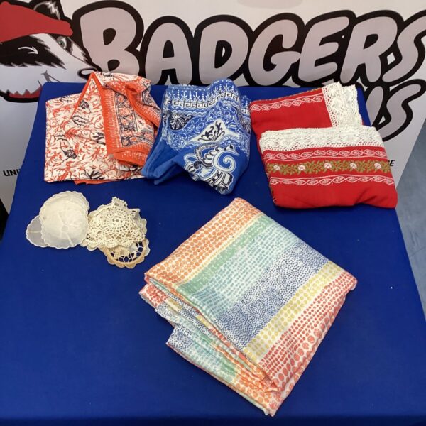 Vintage tablecloth and coaster lot with colourful patterns.