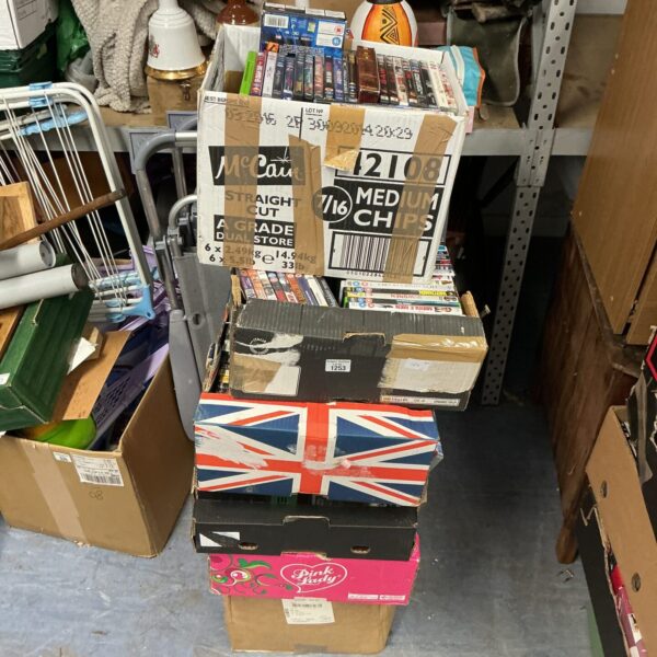 Stacked cardboard boxes filled with a large DVD collection for movie nights.