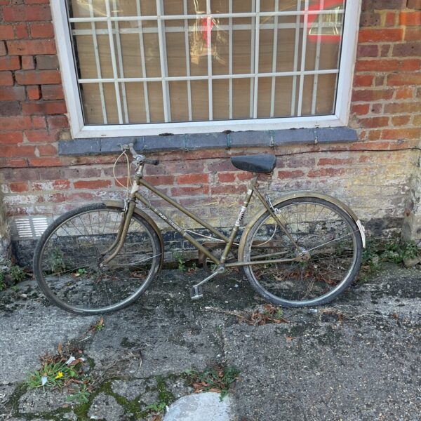 Side view of a vintage touring bicycle in need of restoration.