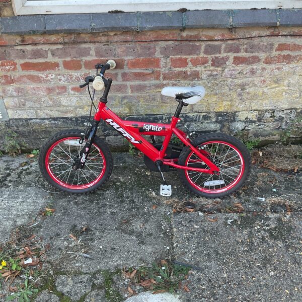 Red Huffy Ignite children’s bike with training stabilisers.
