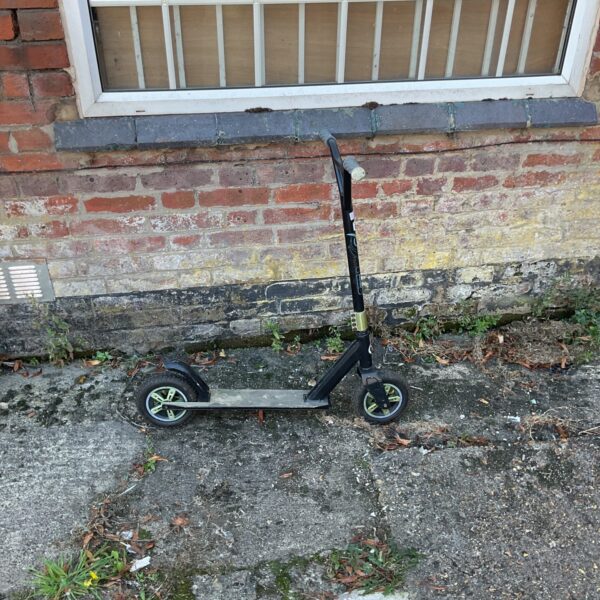 Black Evo scooter for children, showing signs of use.