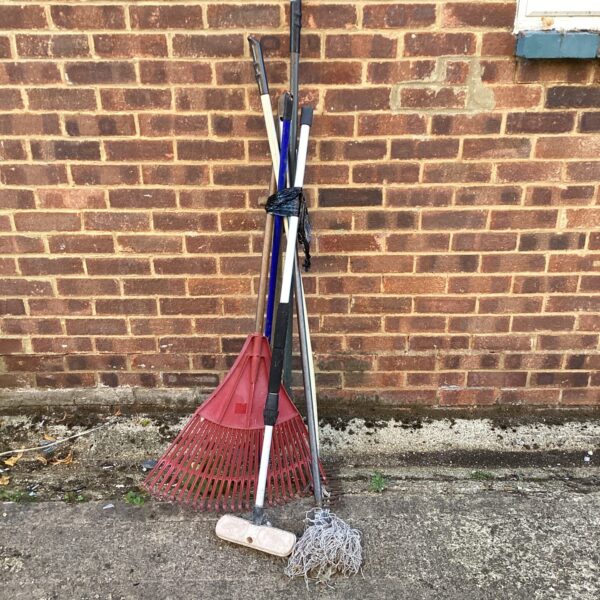 Garden tool bundle featuring a red rake and edging tool.