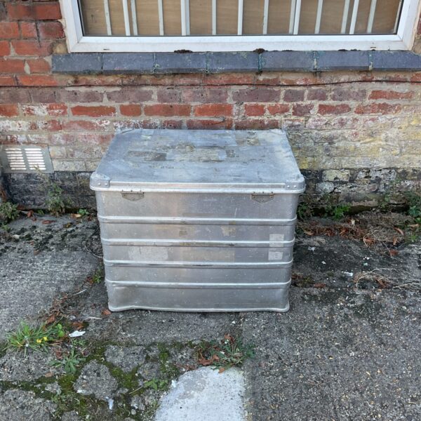 Vintage aluminium transport case sitting outside a brick wall.