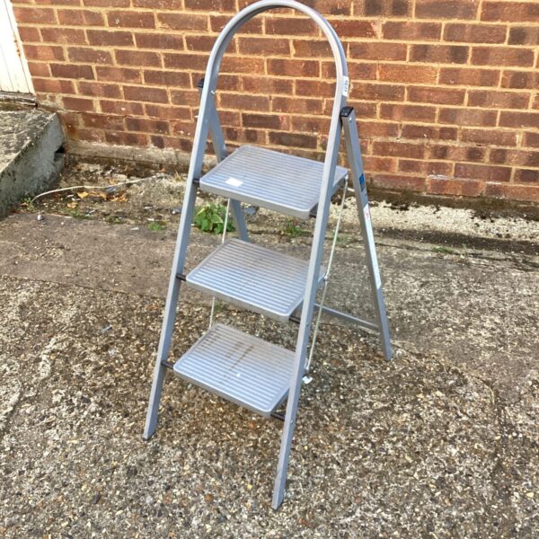 Silver Abru step ladder with three steps, folded for storage.
