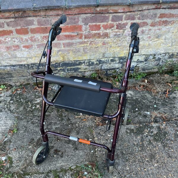 Used mobility aid walker with four wheels and padded seat.