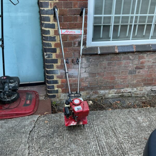 Used Mantis petrol rotavator for garden soil cultivation.