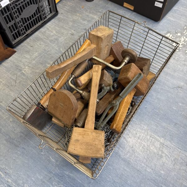 Vintage woodworking tools in a basket, antique hand planes and chisels.