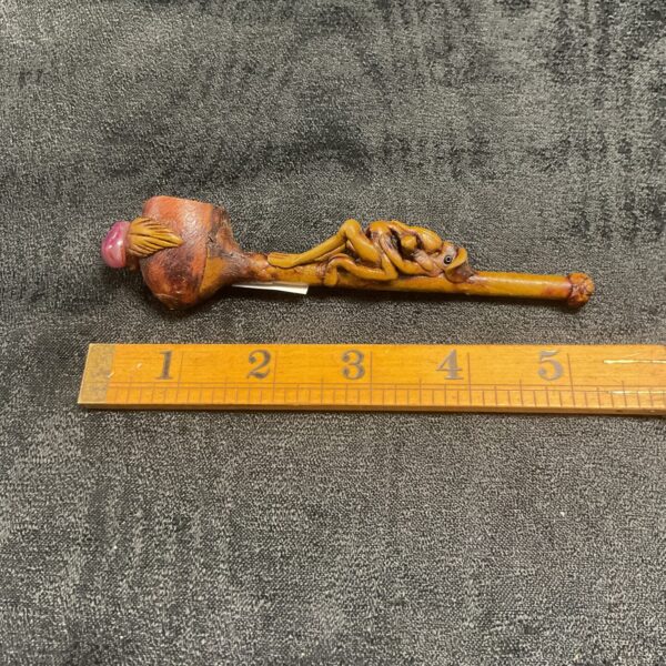 Detailed ceramic novelty pipe with colourful creature design.