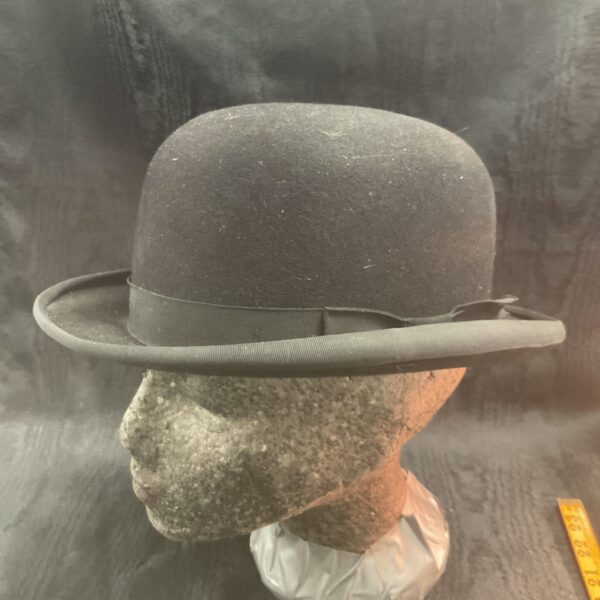 Dark felt vintage bowler hat on display.