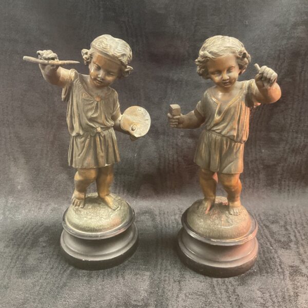 Antique bronze cherub sculptures depicting an artist and sculptor.
