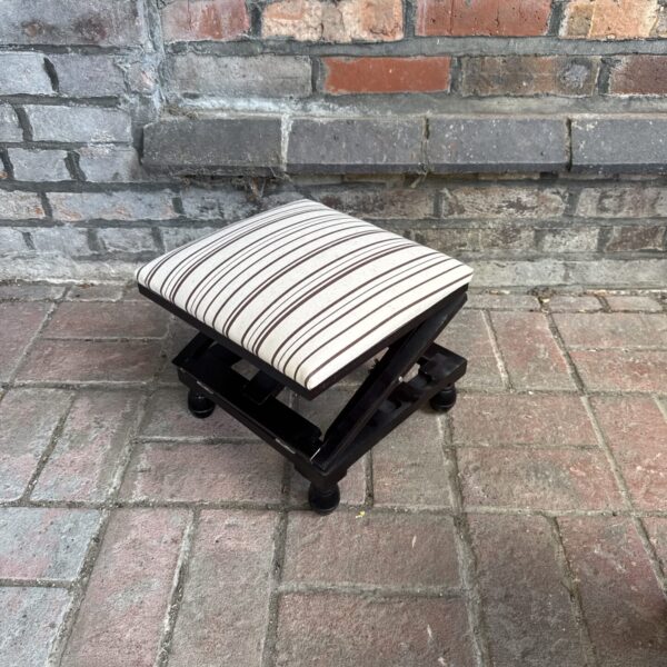 Vintage adjustable foot stool with striped upholstery.