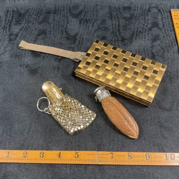 Vintage gold coin purses and compact set on purple background.