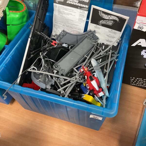 Box containing hotwheels forumla pro racing track sets and vehicles