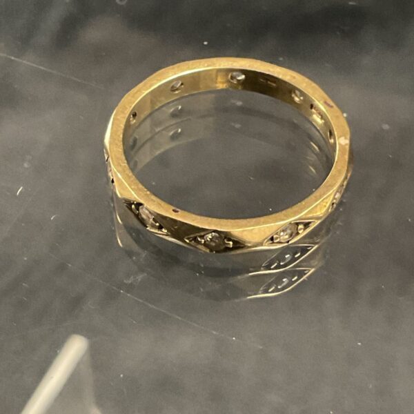 Close-up of a 9ct gold diamond ring with ten diamonds.