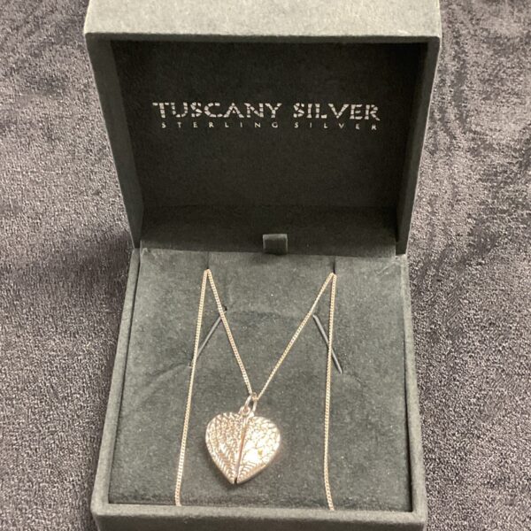 Close-up of 925 silver heart pendant necklace on a display card.