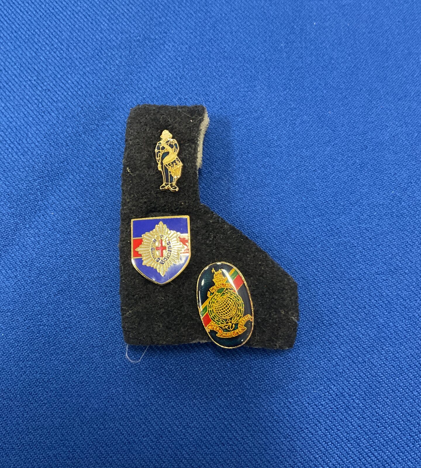 Three military related pin badges