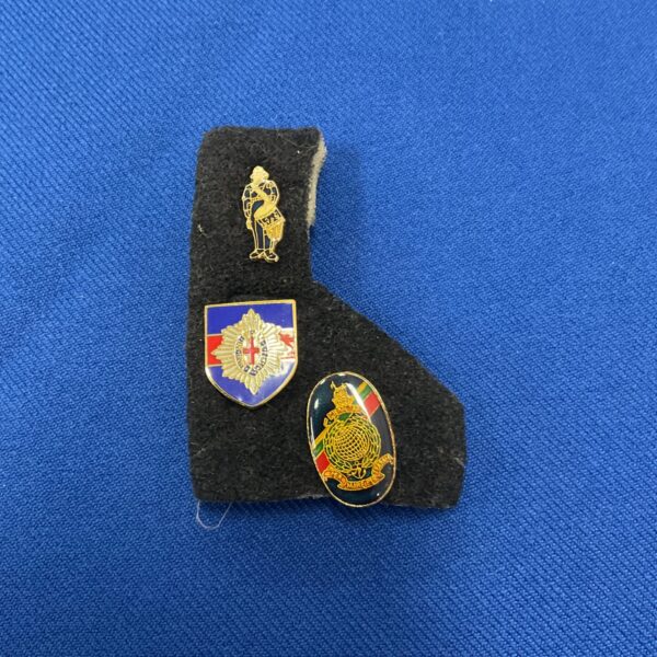 Three military related pin badges